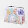 Colorful gift bag with floral, rainbow, and butterfly design, perfect for celebrations and special occasions.