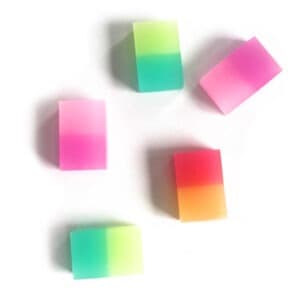 Colorful gradient soap bars with vibrant pastel shades, arranged on a white surface, showcasing artistic bath and skincare products from The Wraperie.