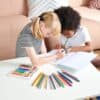 Colorful children drawing with crayons and markers at home, promoting creativity and artistic expression.
