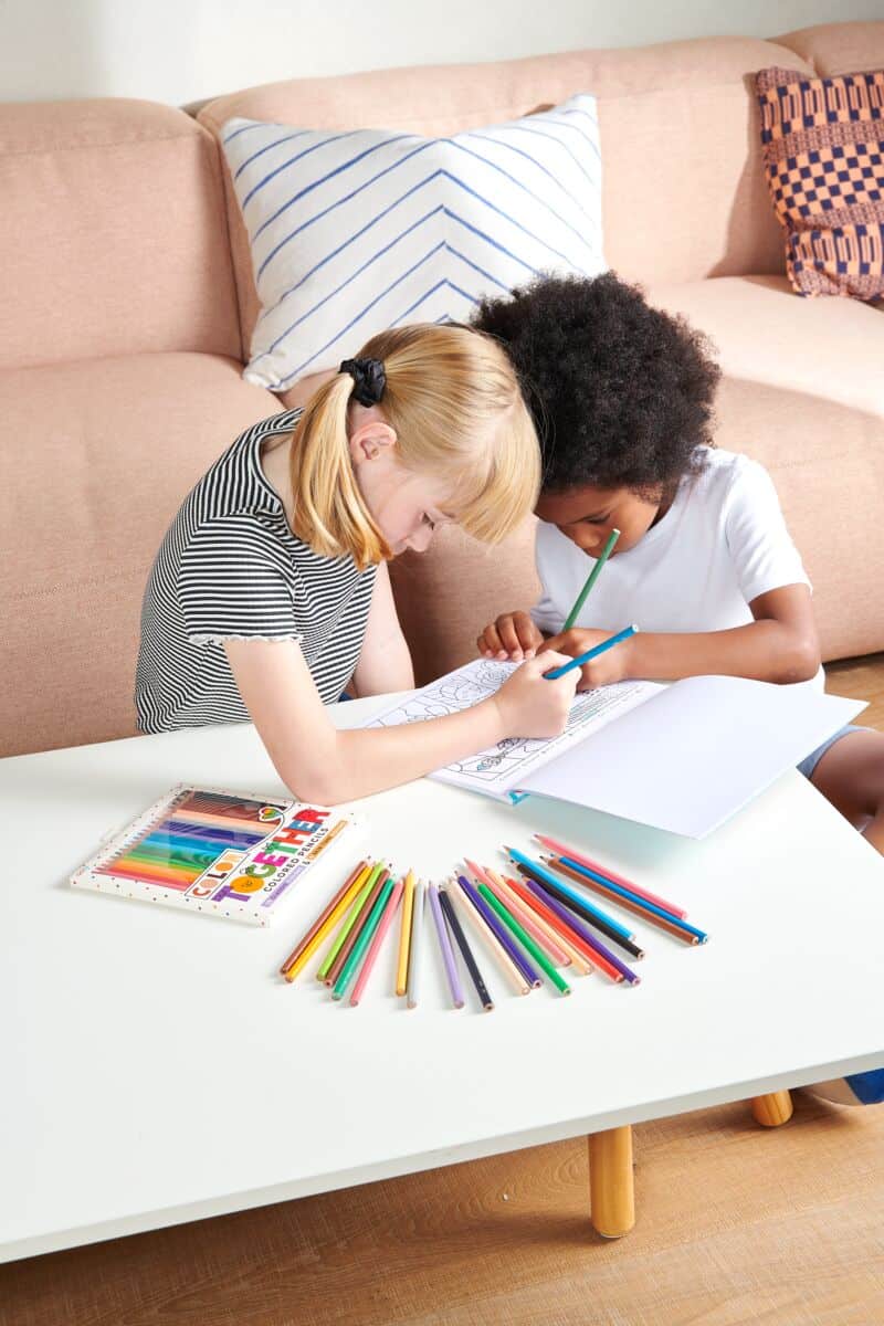 Colorful children drawing with crayons and markers at home, promoting creativity and artistic expression.