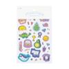 Bright colorful sticker sheet featuring playful cartoon designs including a taco, dinosaur, pear, diamond, jellyfish, and various fun phrases like "Bravo Cado!", "Dino-Mite!", and "Shine On!". Perfect for kids' crafts and decorating journals.