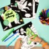 Brightly colored dinosaur-themed coloring pages and markers for kids at The Wraperie, promoting creative fun and artistic development among children.
