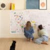 Colorful collaborative coloring activity by children in a modern, stylish home interior, featuring artwork and a black cat, ideal for kids' art projects, creative play, family activities, and home decor.