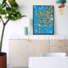 Colorful illustrated map of France with landmarks and scenery, framed and displayed on a white modern sideboard in a stylish interior.