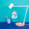 Colorful lamp with castle and dog print, modern desk lamp design, vibrant background, decorative home or kids' room lighting accessory, appealing and playful decor piece for cozy spaces.