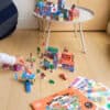 Colorful cardboard city-building toy set featuring buildings, vehicles, and miniature characters, perfect for kids' imaginative play and urban-themed activities.
