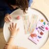Colorful nail sticker decorating a child's fingernails, showing fun and creative nail art activities for kids at The Wraperie.