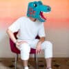 Colorful dinosaur-themed costume head for restaurant branding, playful mascot, unique food presentation, vibrant decor, family-friendly atmosphere at The Wraperie.