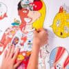 Fun, colorful anatomical illustration of the human body highlighting various organs and systems, designed for educational and health awareness purposes. Features interactive and engaging artwork by The Wraperie.