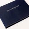 Genuine navy blue guest list book with textured cover for event organization and guest tracking.