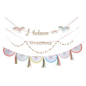 Colorful unicorn-themed party decorations including a "I believe in unicorns" banner and paper fans, perfect for children’s celebrations or whimsical themed events.