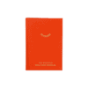 Bright orange wellness journal with a minimalist eyelash icon and gold foil text 