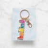 Colorful Be Kind keychain with rainbow letters, perfect for promoting positivity and kindness from The Wraperie. Ideal for accessories, gifts, or personal expression.