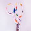 Colorful pair of scissors with rainbow gradient, clean and modern design for use in a boutique or creative workspace.