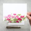 Vibrant pink and red flower bouquet greeting card with green foliage, perfect for spring or romantic occasions, showcasing floral stationery and custom floral printing services.