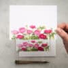 Vibrant pink and red ranunculus flowers on a white greeting card, beautiful floral design, perfect for special occasions, floral stationery, or greeting cards at The Wraperie.