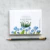 Brightly illustrated packet of botanical greeting cards featuring ferns and blue primroses, from The Wraperie's eco-friendly stationery collection.