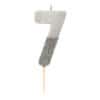 Silver number 7 birthday candle with glitter and white flame on white background.