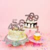 Colorful birthday cakes with number sparklers on a pink background, decorated with rainbow sprinkles and celebratory elements, perfect for birthday celebrations and cake lovers.