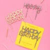 Colorful birthday cake toppers with glitter and sprinkle details, perfect for celebrations, from The Wraperie.
