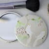 Elegant fabric-covered compact mirror with floral design for beauty and makeup touch-ups, perfect for personalized gifts or accessories.