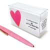 Bright pink pen with gold clip and a clear plastic box labeled 