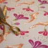 Colorful floral wrapping paper with scissors and ribbon for gift wrapping.