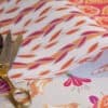 Colorful fabric with floral and leaf patterns, perfect for wrapping gifts and creative projects.