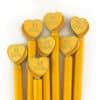 Bright yellow pencils with heart-shaped toppers engraved with "BE KIND" for promoting kindness and positivity.