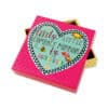 Bright pink compact mirror with colorful heart, bee, and bird illustrations, featuring the quote 