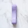Soft purple ribbon roll on white marble surface, ideal for gift wrapping, crafts, and decorations. Elegant, vibrant, and versatile ribbon perfect for adding a pop of color to any project.