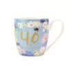 Bright floral mug celebrating a 40th birthday with gold lettering and colorful flower illustrations, perfect for milestone celebrations and gifting.
