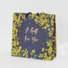 Vibrant gift bag from The Wraperie featuring yellow floral design and bees, perfect for special occasions and gift wrapping. A stylish, eco-friendly packaging option for gifts.
