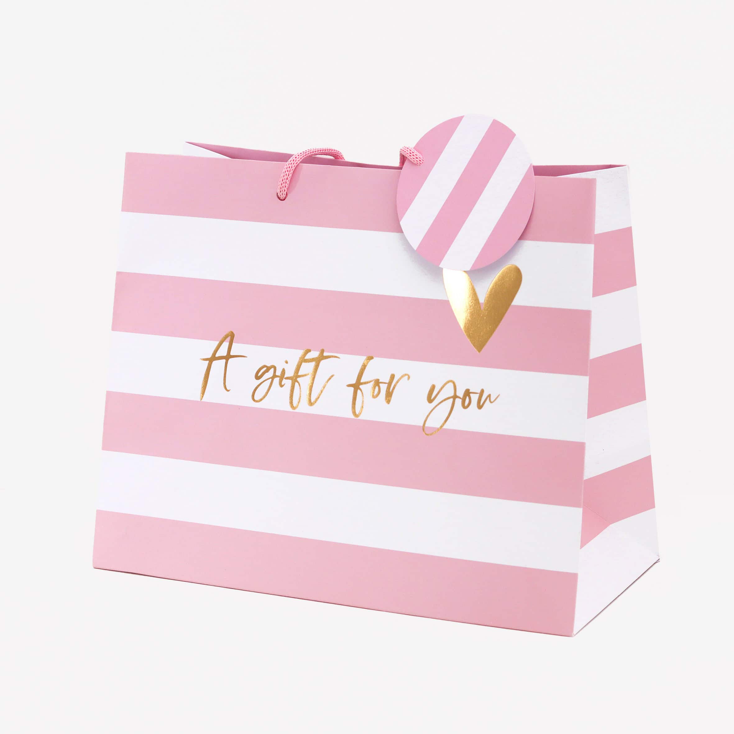 Pink and white gift bag with "A gift for you" lettering, gold heart accent, and pink striped round tag, perfect for special occasions and celebrations.