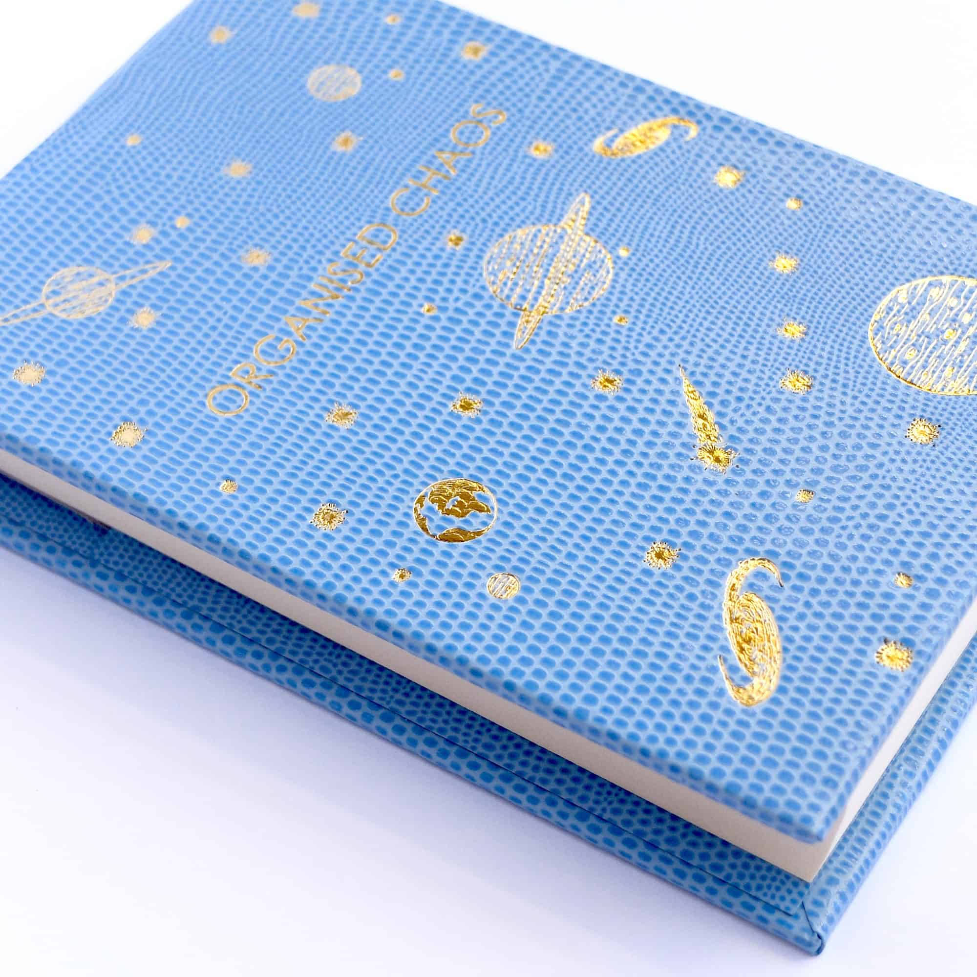 Golden space-themed wrap from The Wraperie with planets, stars, and celestial illustrations on a blue textured background, perfect for eco-friendly food presentation.