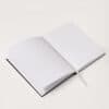 A sleek, open planner or journal with lined pages on a clean white surface, ideal for daily schedules and note-taking.