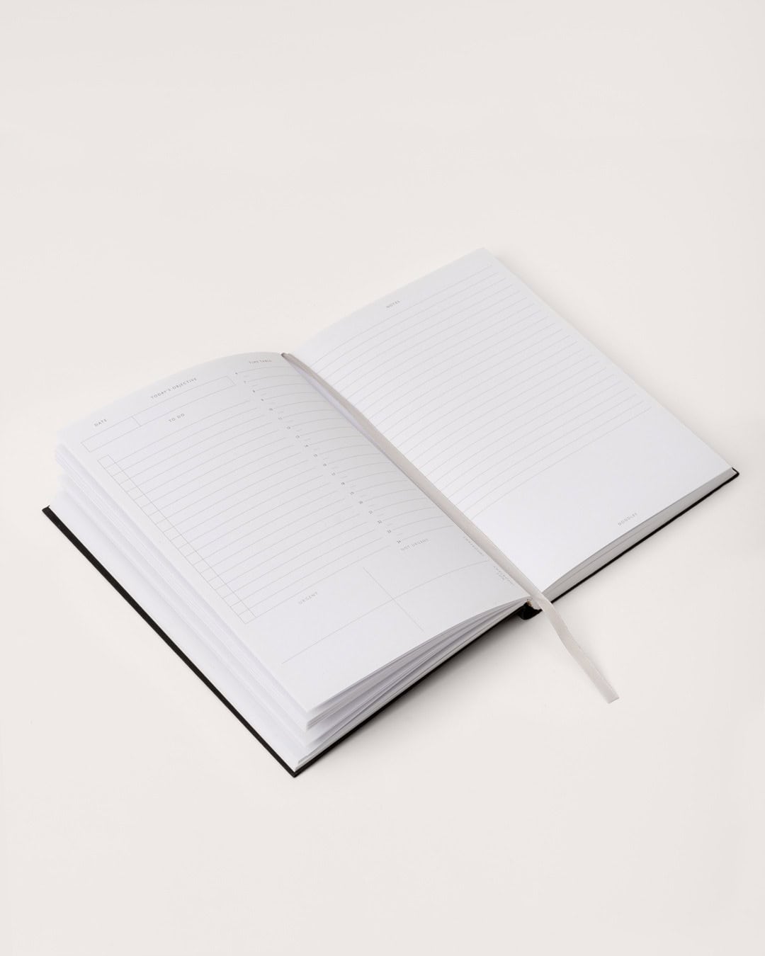 A sleek, open planner or journal with lined pages on a clean white surface, ideal for daily schedules and note-taking.