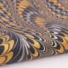 Vibrant marbled paper with intricate yellow, black, gray, and white swirling patterns, perfect for craft projects, gift wrapping, or artistic decoration.