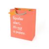 Spoiler alert, it's not a puppy, humorous gift bag with playful text showcasing fun merchandise at The Wraperie.