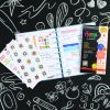 Colorful planner with stickers, notebooks, and chalkboard background for creative organization and school supplies.