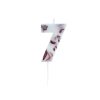 Number 7 birthday candle with rose petals embedded in white wax on a white background.