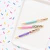 Colorful pens with inspirational quotes on a white tray, set against a playful confetti background. Perfect for writing, gifting, or desk decor, showcasing vibrant designs and motivational messages.