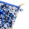 Blue sequin and glitter makeup bag with gold zipper and keyring, stylish and functional accessory for cosmetics or personal items.