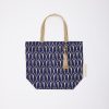 Vegan tote bag with navy blue and gold geometric pattern, featuring durable straps and a stylish tassel accent, perfect for shopping or everyday use.
