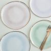 Elegant disposable paper plates with rose gold foil edges, perfect for stylish parties and gatherings, adding a touch of luxury to your table setting.