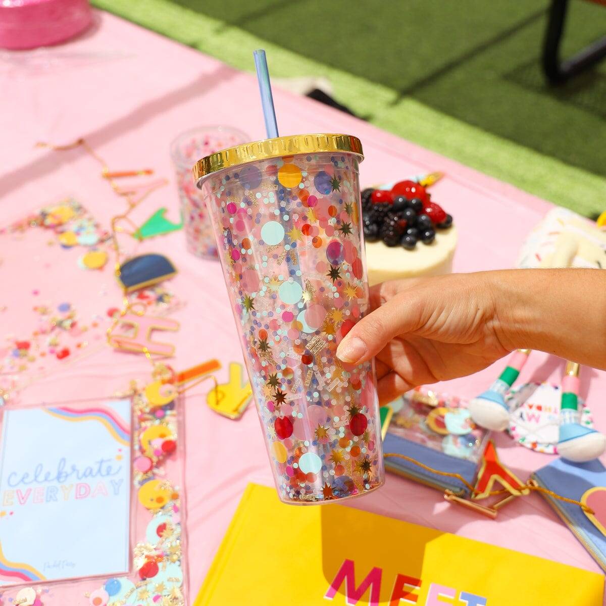 Confetti-covered reusable tumbler with a blue straw, perfect for celebrating daily with colorful accessories, desserts, and party decorations.