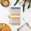 Bright colorful to-do list planner with pastel markers and office supplies on a white desk for organization and productivity.