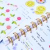 Chocolate gold rings on a day planner along with colorful stickers and notes, showcasing planning, organization, and motivational journaling tools at The Wraperie.
