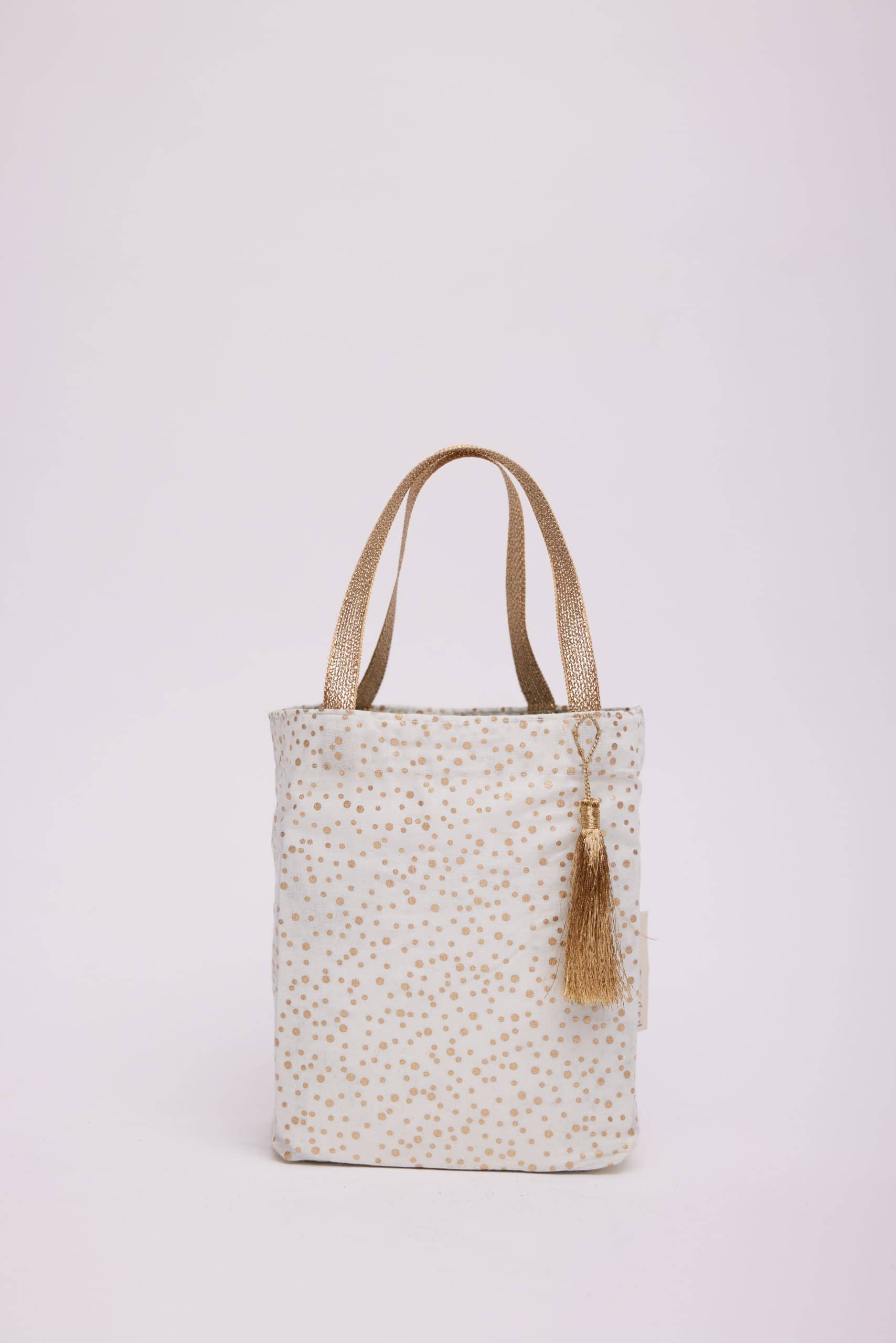 Cream and gold polka dot tote bag with tassel, stylish and versatile accessory from The Wraperie for everyday use or gifting.