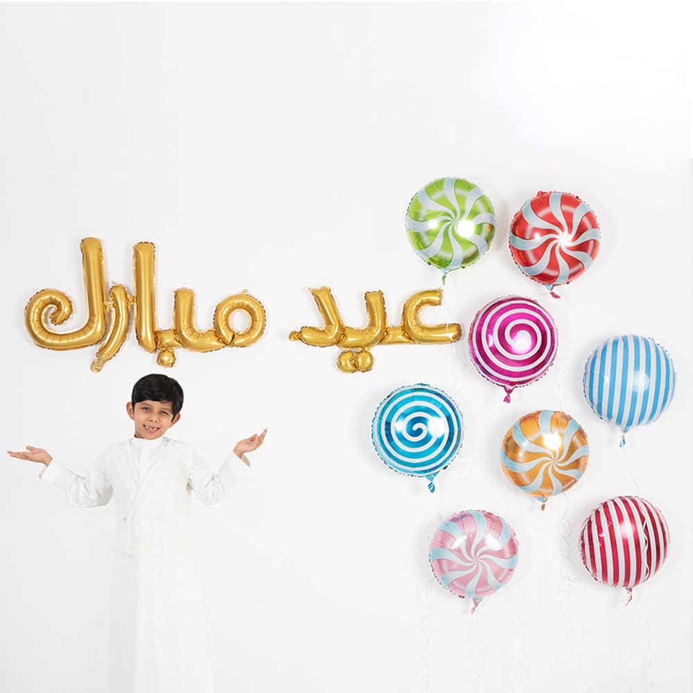 Colorful birthday celebration with helium balloons and "عيد سعيد" (Happy Eid) gold foil balloon, set against a white background, featuring a smiling boy in traditional attire.